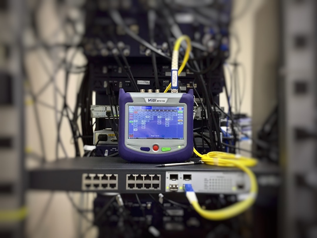 Network testing device with yellow cable in a server room.